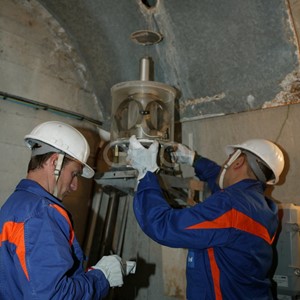 Operazioni di controllo: operai al lavoro su una strumentazione all'interno di un cunicolo della diga di Alpe Gera