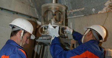 Operazioni di controllo: operai al lavoro su una strumentazione all'interno di un cunicolo della diga di Alpe Gera