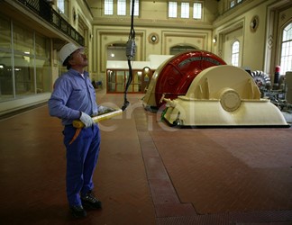 Operaio in sala macchine manovra la pulsantiera che comanda il carroponte