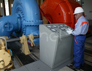 Operaio all'interno della sala macchine: operazioni di controllo su un gruppo turboalternatore