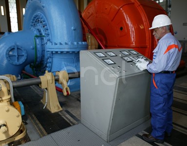 Operaio all'interno della sala macchine: operazioni di controllo su un gruppo turboalternatore