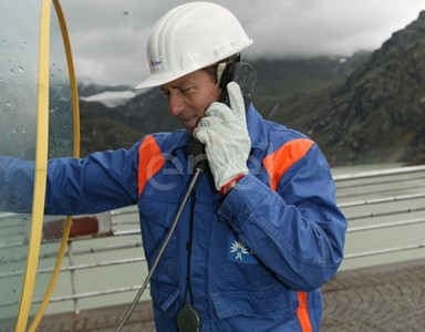 Operaio al telefono sul coronamento della diga di Alpe Gera