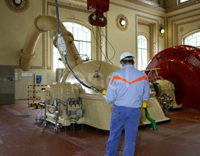 Operaio in sala macchine manovra la pulsantiera che comanda il carroponte