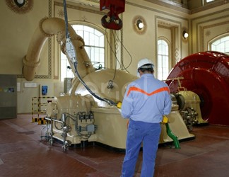 Operaio in sala macchine manovra la pulsantiera che comanda il carroponte