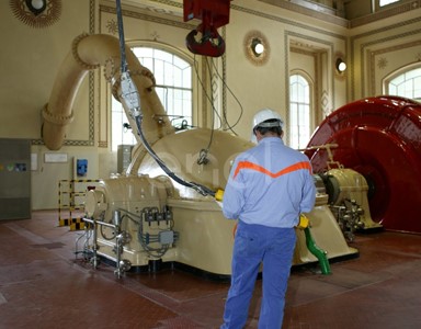 Operaio in sala macchine manovra la pulsantiera che comanda il carroponte