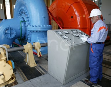 Operaio all'interno della sala macchine: operazioni di controllo su un gruppo turboalternatore