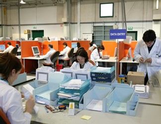 Impiegati al lavoro nel reparto 'Preparazione digitalizzazione' di documenti