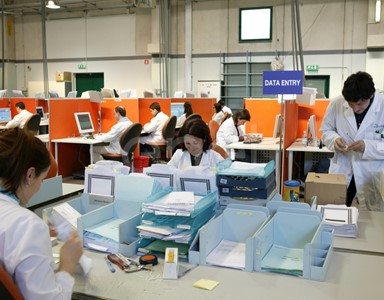 Impiegati al lavoro nel reparto 'Preparazione digitalizzazione' di documenti