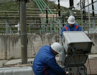 Operai eseguono test di controllo su un trasformatore trifase all'interno della stazione elettrica di trasformazione della centrale di Presenzano