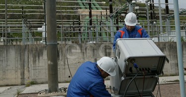 Operai eseguono test di controllo su un trasformatore trifase all'interno della stazione elettrica di trasformazione della centrale di Presenzano