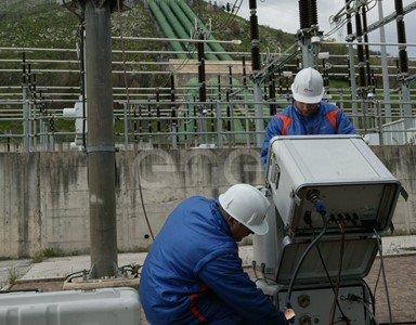 Operai eseguono test di controllo su un trasformatore trifase all'interno della stazione elettrica di trasformazione della centrale di Presenzano