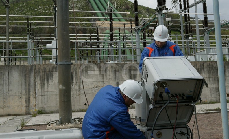 Operai eseguono test di controllo su un trasformatore trifase all'interno della stazione elettrica di trasformazione della centrale di Presenzano