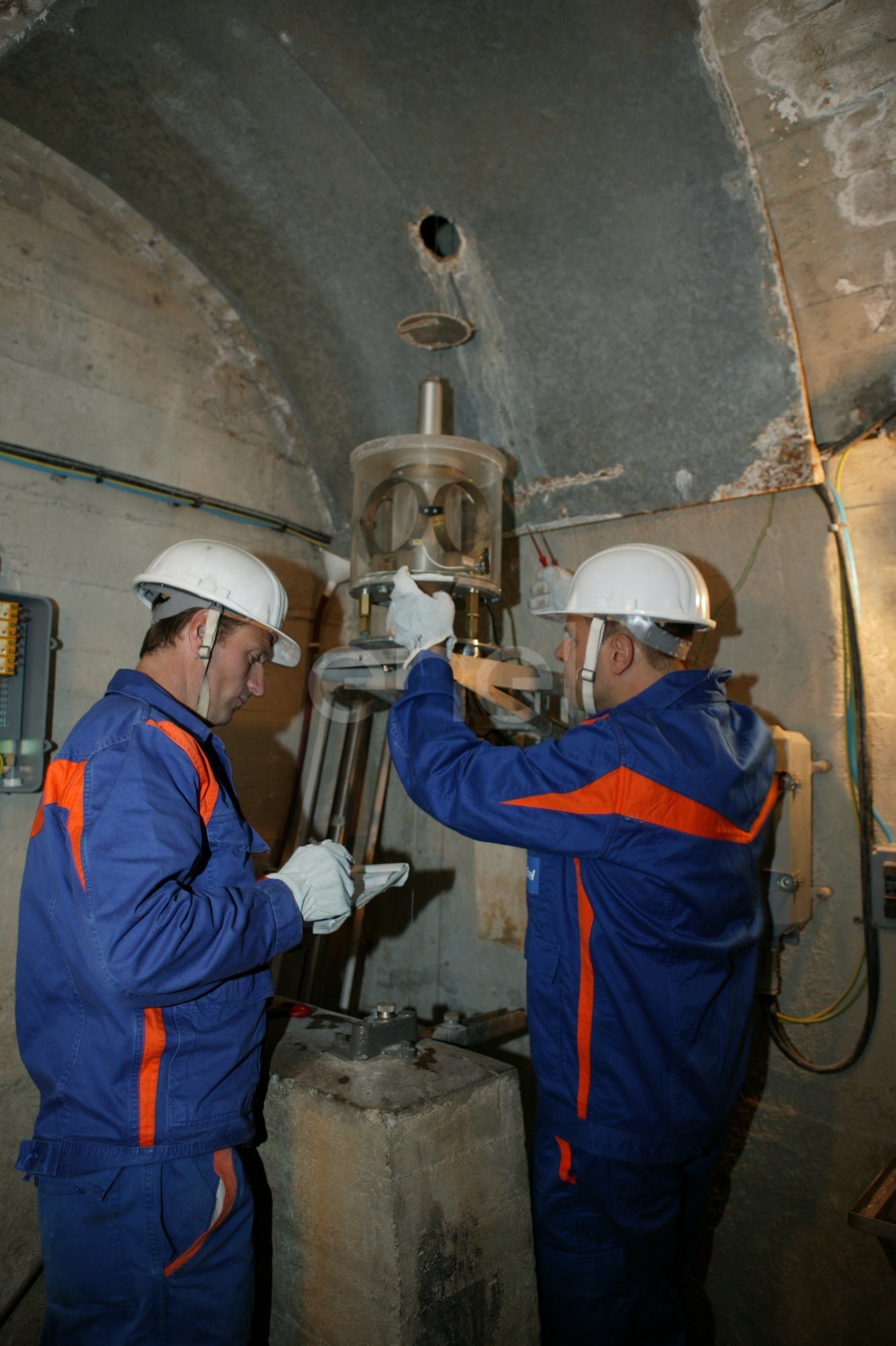 Operazioni di controllo: operai al lavoro su una strumentazione all'interno di un cunicolo della diga di Alpe Gera