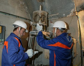 Operazioni di controllo: operai al lavoro su una strumentazione all'interno di un cunicolo della diga di Alpe Gera