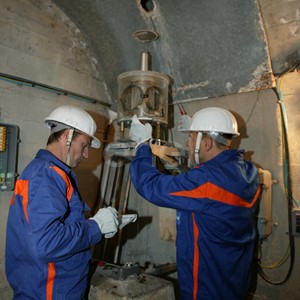 Operazioni di controllo: operai al lavoro su una strumentazione all'interno di un cunicolo della diga di Alpe Gera