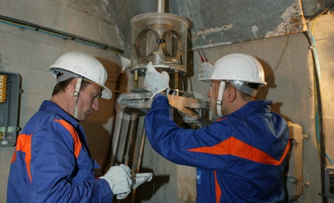 Operazioni di controllo: operai al lavoro su una strumentazione all'interno di un cunicolo della diga di Alpe Gera