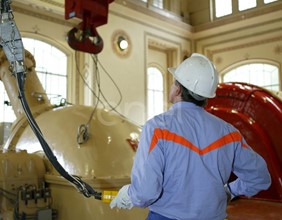 Operaio in sala macchine manovra la pulsantiera che comanda il carroponte
