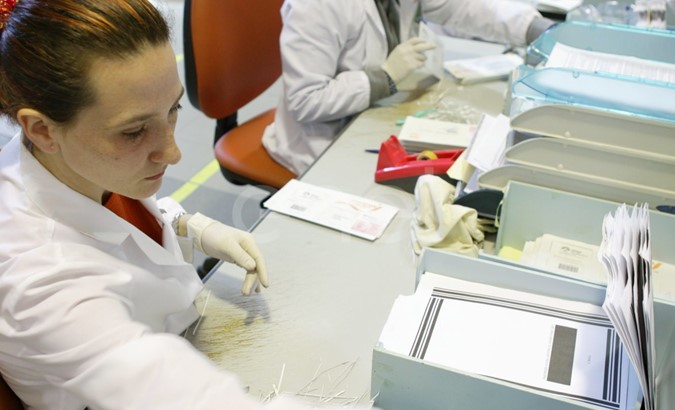 Impiegati al lavoro nel reparto 'Preparazione digitalizzazione' di documenti