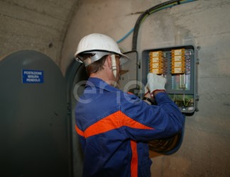 Operazioni di controllo: operai al lavoro su una strumentazione all'interno di un cunicolo della diga di Alpe Gera