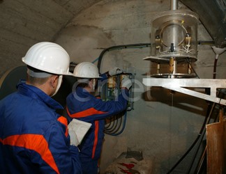 Operazioni di controllo: operai al lavoro su una strumentazione all'interno di un cunicolo della diga di Alpe Gera